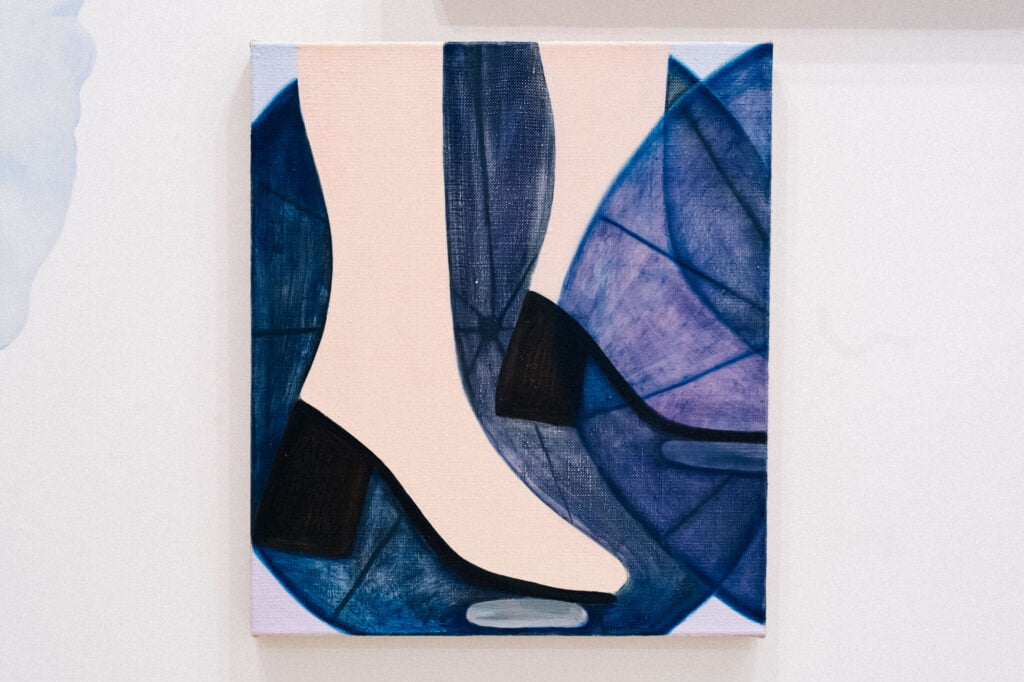 A painting of light flesh-coloured shoes on heels, or feet with black heels and soles with purple shapes surrounding them