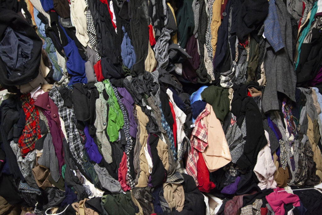 Pile of second hand clothes, different colours and fabrics, seen from above