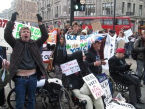 A crowd of people from 'Disabled People Against Cuts' protesting against the disability pay gap on Regent's Street, London, 2012.