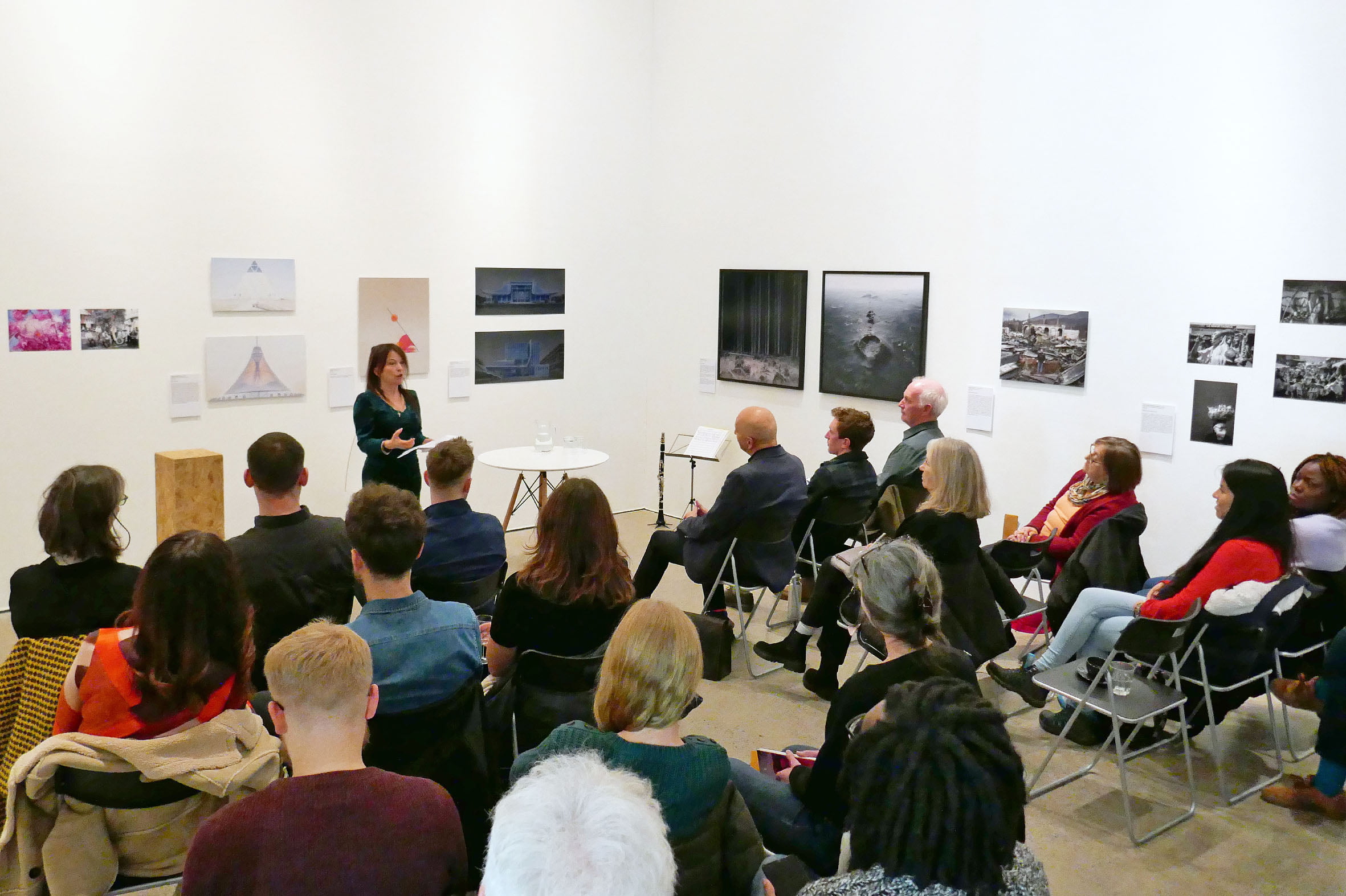 People in room sat watching Maria Isakova-Bennett