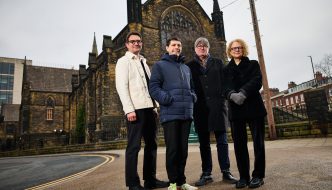 A photo of four people in front of a building in Leeds