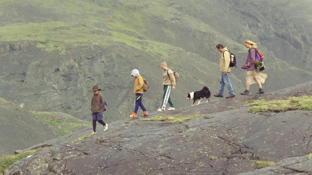 Image of a family walking in a mountainous landscape. 