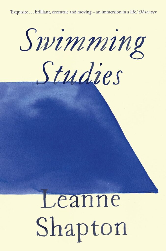A beige book cover for 'Swimming Studies' by Leanne Shapton, featuring a half of a dark blue trapezium with the title and name of the author in italics and a darker blue above and below. 